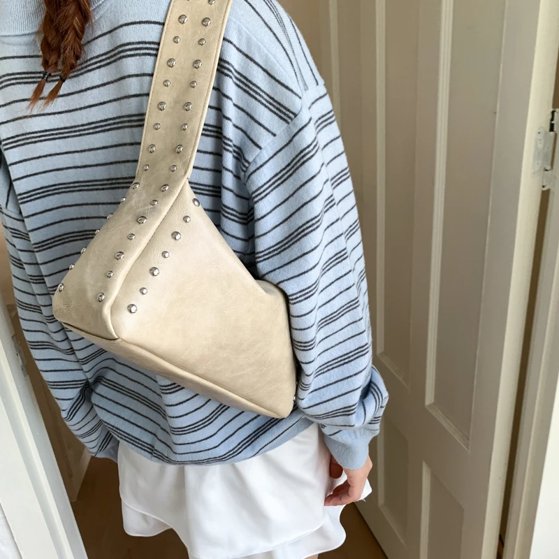 Women Bags 2026 Trends - オリジナルデザインのリベット付きソフトレザー製、バイカースタイルのアンダーアームバッグ。高級感のある小ぶりなサイズで、2026年新作。女性向けのハンドバッグ、最新ファッショントレンド。